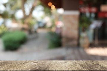Empty dark wooden table in front of abstract blurred boken bankground of restaurant. Can used for display or montage your products. Mock up for space.
