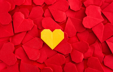 Obraz premium Yellow origami heart on red origami hearts
