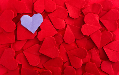 Purple origami heart on red origami hearts