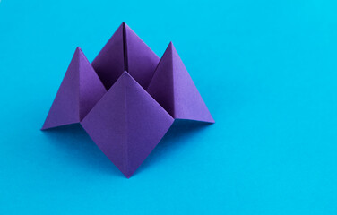 Origami paper fortune on blue background