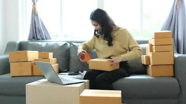 Young Asia businesswoman using mobile phone call receiving purchase order and check product on stock, work at home office. Small business owner, online market delivery, lifestyle freelance concept.