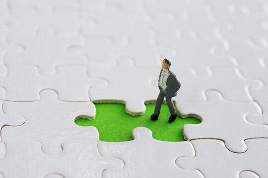 Businessman figurine on jigsaw piece