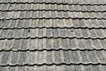 Concrete roof tiles. Old style architecture. Countryside house roof. Tiles texture. Weathered,...