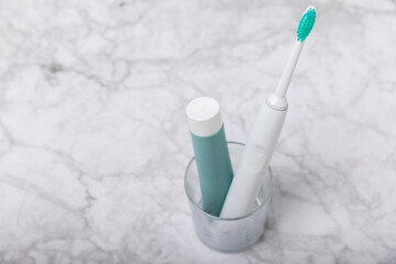 Toothbrush and tube of toothpaste on marble background with copy space. Flat lay. Oral hygiene. Oral Care Kit. Dentist concept. Place for text. Place to copy.