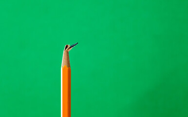 Broken pencil tip on green background