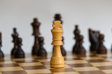 White check against black chess pieces. Checkmate concept. Chess board game concept background. Wood chess pieces on board game. Selective focus area. 