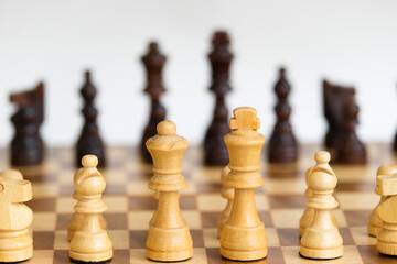 White check against black chess pieces. Checkmate concept. Chess board game concept background. Wood chess pieces on board game. Selective focus area.