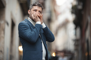 An adult man plays the harmonica on the street
