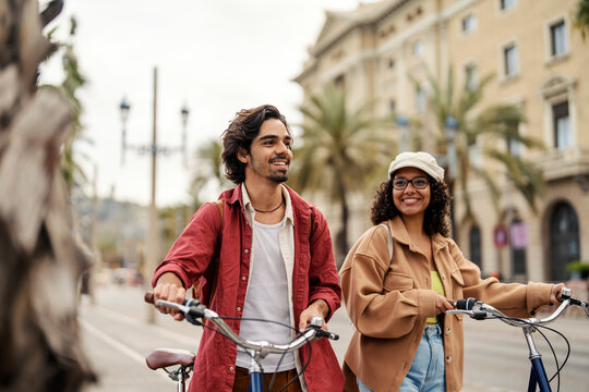 A cheerful tourists visiting an European metropolis while pushing bikes aside.