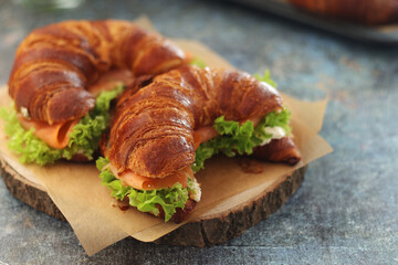 Freshly baked croissants with salmon and salad on the table