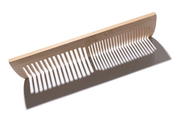 Wooden comb made of natural material with hard shadow. On a white background.