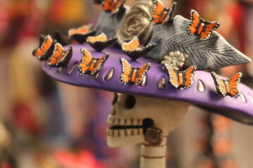 face of a handmade catrina with a hat decorated with traditional monarch butterflies from michoacan