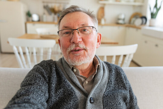 Happy middle aged senior man talk on video call with friends family. Laughing mature old senior grandfather having fun speaking with grown up children online. Headshot portrait selfie webcamera view
