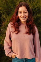 Portrait of young Caucasian woman standing outside and smiling.