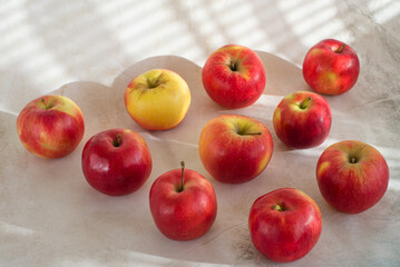 Jabłka czerwone świeże rozrzucone na jasnym tle