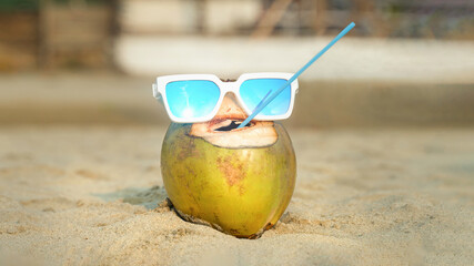 cheerful drinking coconut with plastic straw in its mouth