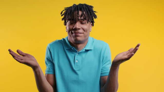 Confused young african man,shoulders up can't help, makes gesture of I dont know