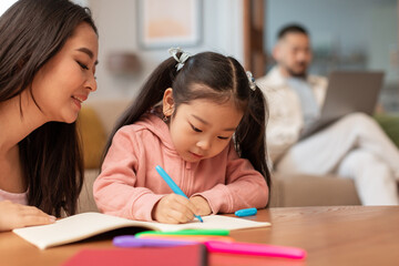 Korean Mother Teaching Little Daughter Writing Skills At Home