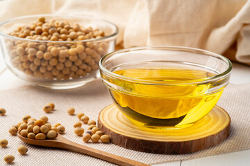 Soybean oil,is a vegetable oil extracted from the seeds of the soybean,in glass bowl on wooden table