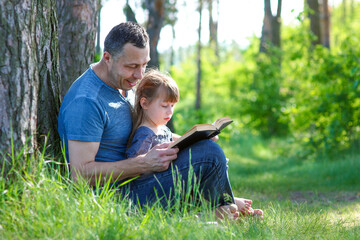 father and daughter reading bible book