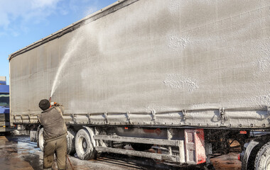 Washing a large truck with car shampoo. Background for car service. Truck washing outdoors....