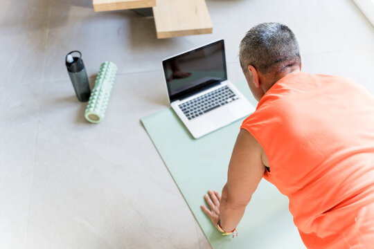 Close-up Of An Unrecognizable Overweight Person Doing Indoor Sports Following Online Classes