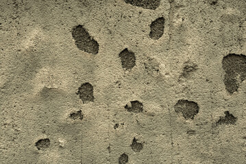 A surface of a concrete wall with huge deep chips