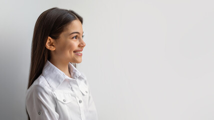 Side View Of Happy Middle Eastern Girl Against White Wall