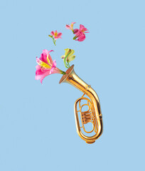 Creative concept of tuba musical instrument with flying colorful lily flowers.