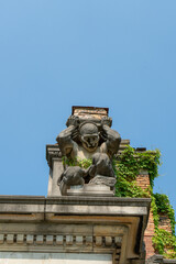 Obraz premium carved stone figure from the ruins of a skyscraper overgrown with ivy