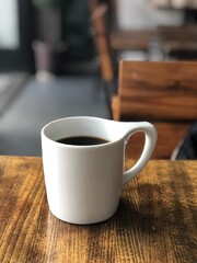 Black coffee in white coffee mug on rustic wooden table