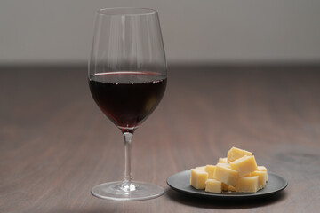 glass of red wine with vintage cheese on small plate
