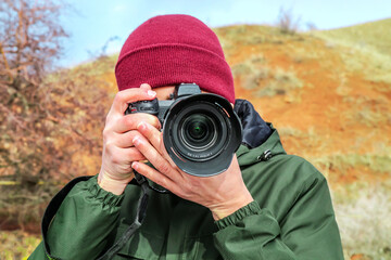 Obraz premium Professional camera in the hands of a male photographer in the mountains