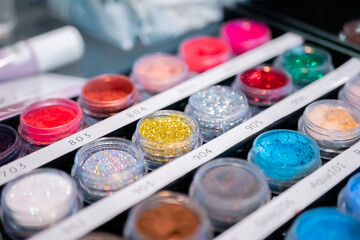 Set of cosmetic makeup glitter in row for sale in makeup store on counter for sale in makeup store...