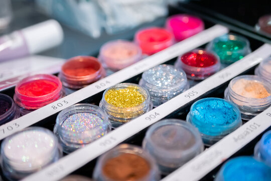 Set of cosmetic makeup glitter in row for sale in makeup store on counter for sale in makeup store - close up, selective focus. Glamour, fashion, make up, beauty and skincare concept