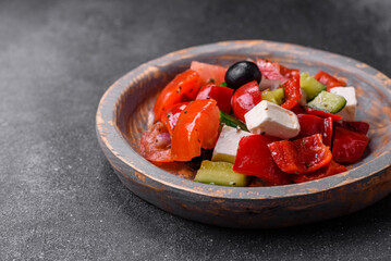 Delicious fresh juicy greek salad with feta cheese, olives, peppers and tomatoes