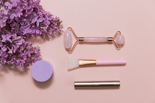 Beauty products on a pink background with lilac