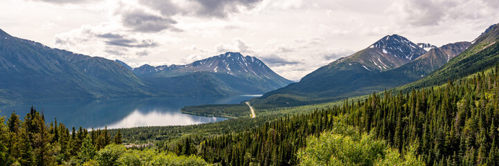 Panoramic views over a wilderness area near Alaska during summer time with bright cloud sk. Beautiful scenic landscape in Yukon British Columbia. 