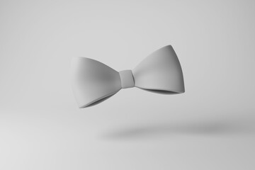 White bowtie casting shadow on white background creating greyscale monochrome. Illustration of the concept of minimalism, dress code, formal events and courtesy