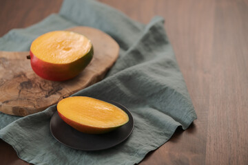 Freshly cut ripe mango on olive board