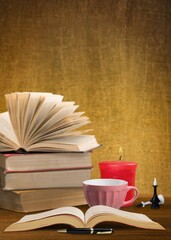 Naklejka premium Stack of old vintage books and cup of tea