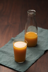 Fresh organic orange juice in tumbler glass on wood table