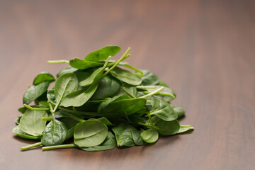 Fresh spinach leaves on walnut wood table