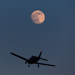 full moon over the sky and a small plane