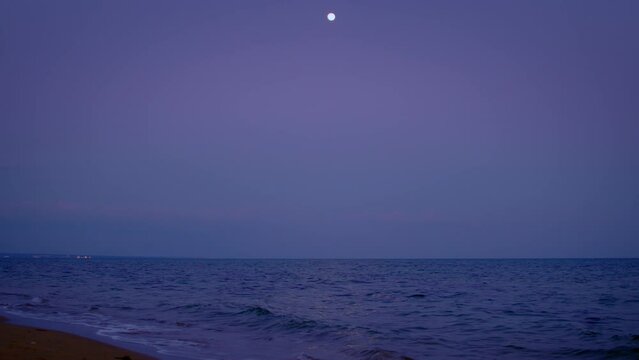 Full moon, moon over sea surface at night, moon track on water surface, camera tracking