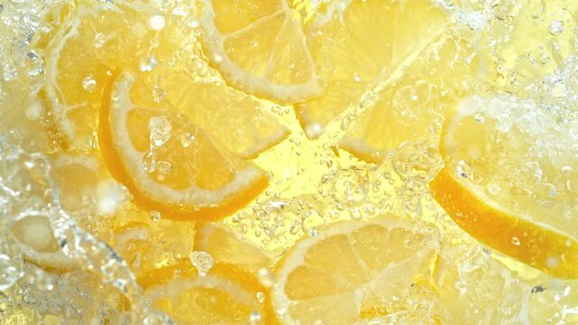 Super Slow Motion Shot of Fresh Lemon Slices Falling into Water Whirl at 1000 fps.