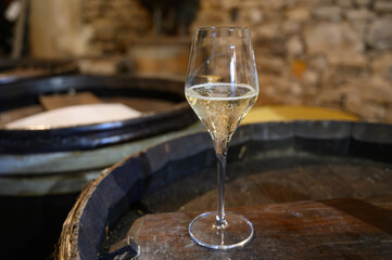 Tasting of grand cru sparkling white wine with bubbles champagne by old champagne caves in grand cru wine producer small village Cramant, Champagne, France