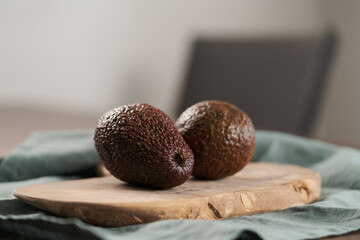 Two avocados on olive wood board