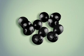 Black tasty olives on the colored background