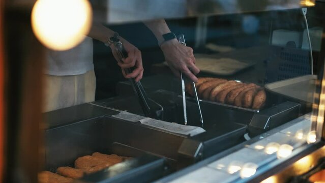 Unrecognizable chef fries chebureks and pies at a fast food point, close-up